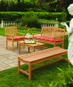 a wooden bench sitting next to a statue on top of a green grass covered field