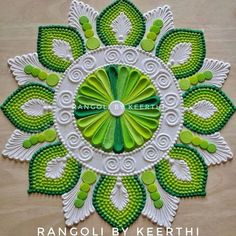 a green and white circular design with leaves on the center is featured in this handmade wall hanging