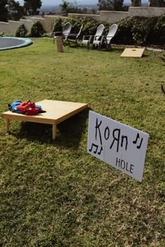 a wooden table sitting on top of a lush green field