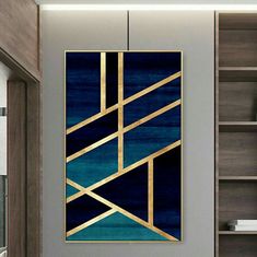 a blue and gold art piece hanging on the wall in a room with bookshelves