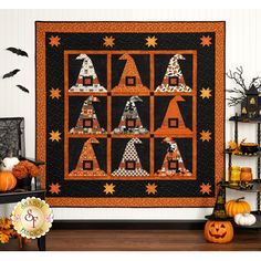 a quilted halloween scene with pumpkins and witch's hats on the wall