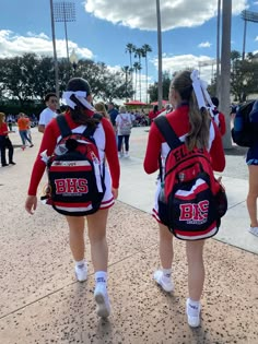 two girls in red and white uniforms are walking together