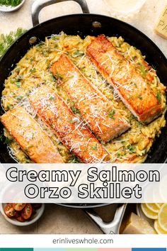 creamy salmon orzo skillet with parmesan cheese on top and lemon wedges