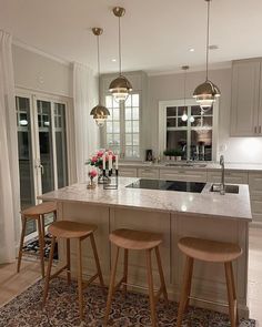 a kitchen with two stools and an island in the middle of the room,