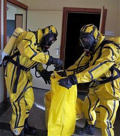 two people in yellow suits and gas masks