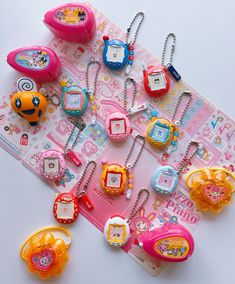 many different types of watches and necklaces on a white table with a pink background