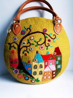 a yellow purse with houses and trees on it