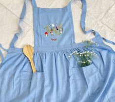 a blue apron with flowers and a wooden spoon