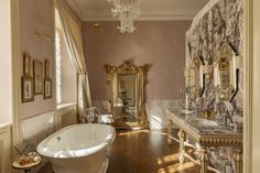 a fancy bathroom with an ornate tub and chandelier