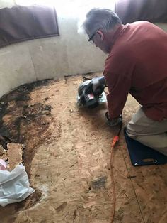 a man is working on the floor in an unfinished room