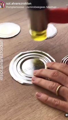 a person's hand on top of a wooden table