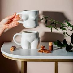 A set of two ceramic mugs that stack to create the female form.These two large, brilliant white mugs, form a stunning female form silhouette when stacked.A great housewarming present. The generous size of the mugs would be perfect for flowers.A great gift for that special someone, or why not treat yourself to a new set of fun mugs.