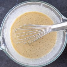 a blender filled with brown liquid and whisk