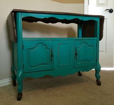 a blue cabinet with black top and drawers on the bottom is next to a white door