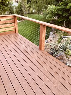 a wooden deck with metal railing and green grass