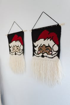 two wall hangings decorated with santa claus's hats and pompom fringes