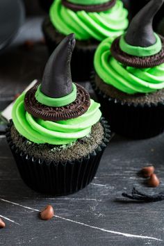 cupcakes decorated with green frosting and black icing