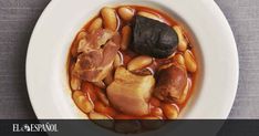 a white plate topped with beans and meat