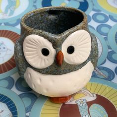 a ceramic owl cup sitting on top of a table