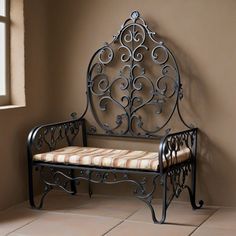 a wrought iron bench sitting in a room with tile flooring and walls behind it