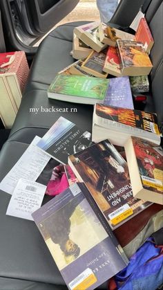 many books are sitting on the back seat of a car