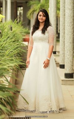 a woman in a white dress posing for the camera