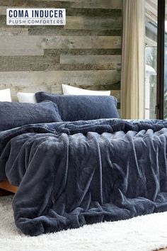 a large bed covered in blue blankets and pillows