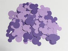 a pile of purple heart shaped confetti sitting on top of a white table