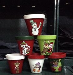 there are many cups that have different designs on them, and one has a snowman painted on it