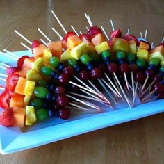 a platter filled with fruit and skewers