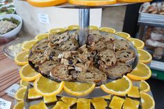 an assortment of pastries are displayed on a platter with orange slices and other food items