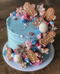 a blue frosted cake topped with lots of gingerbread cookies and snowflakes