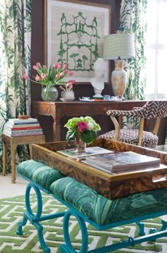 a living room filled with furniture and flowers on top of a coffee table in front of a window