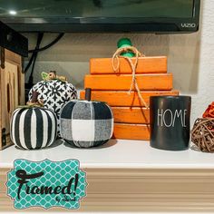 several decorative pumpkins are sitting on a mantle in front of a flat screen tv