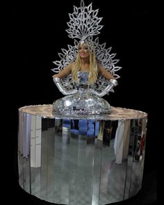 a woman sitting on top of a silver object