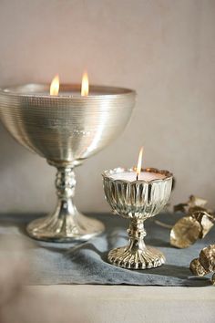 two silver candles sitting next to each other on a table