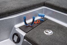 scissors are sitting on the edge of a boat's storage compartment, which is open