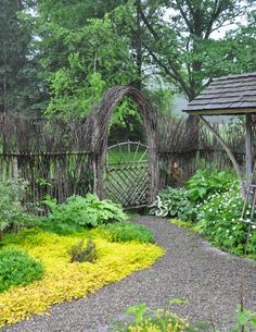 a garden with various types of plants and flowers around it, including trelliss