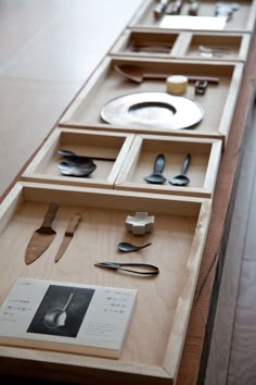 a wooden table topped with lots of different types of utensils and spoons