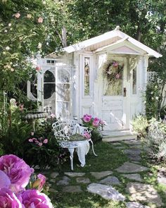 a white gazebo surrounded by pink flowers and greenery