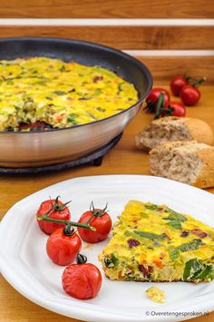 an omelet with tomatoes and bread on a plate next to the casserole