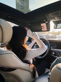 a woman sitting in the driver's seat of a car with her head up