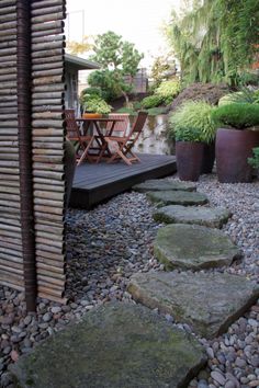 an outdoor patio with stepping stones and potted plants