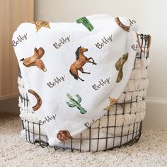 a baby blanket with horses and cactuses on it sitting in front of a door