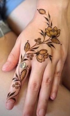 a woman's hand with flowers on it