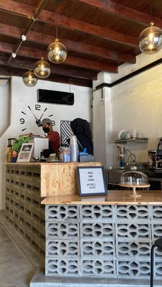 a counter in a restaurant with lights hanging from the ceiling