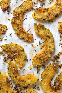 roasted squash with herbs and seasoning on a sheet of parchment paper, ready to be cooked