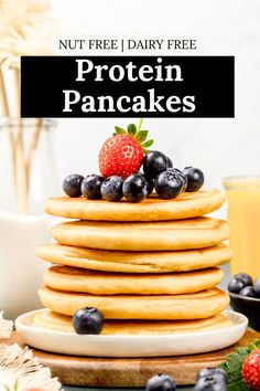 A stack of vegan protein pancakes are on a white plate on the kitchen table. Fresh blueberries and strawberries are on the plate. Juice and flowers are blurred in the background. Text on the image reads, "nut free dairy free protein pancakes". Pancakes Simple, Gluten Free Protein Pancakes, Vegan Protein Pancakes, Pancakes Gluten Free, Banana Protein Pancakes, Dairy Free Protein, Pancake Calories, Best Protein Powder