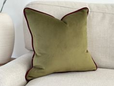 a green pillow sitting on top of a white couch