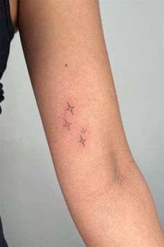 a woman's arm with three small stars on the left side of her arm